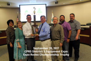 CRPD staff posing with board members and district administrator while holding a trophy won for staff competing in CPRS District 2 Equipment Expo Rodeo