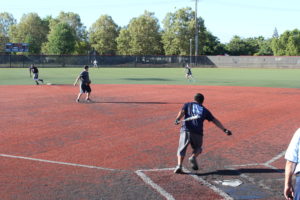 Softball player running to base after hitting ball