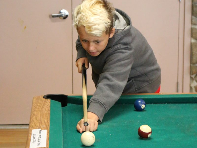 boy playing pool at The HYDE Out Teen Center